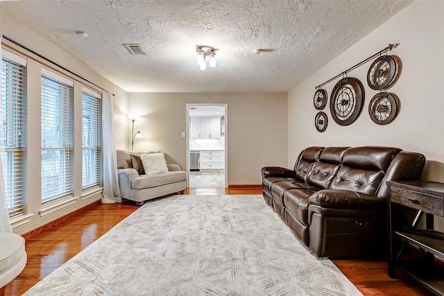22814 Wren Ln, Tomball, TX 77377 - living area featuring wood finished floors, healthy amount of natural light, a textured ceiling, and baseboards