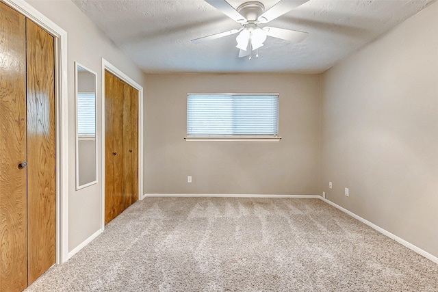 22814 Wren Ln, Tomball, TX 77377 - unfurnished bedroom with carpet flooring, baseboards, a ceiling fan, a textured ceiling, and two closets