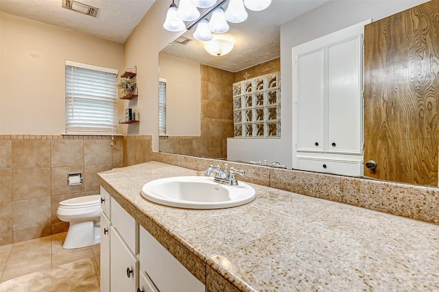 22814 Wren Ln, Tomball, TX 77377 - bathroom with tile walls, a chandelier, tile patterned flooring, toilet, and vanity