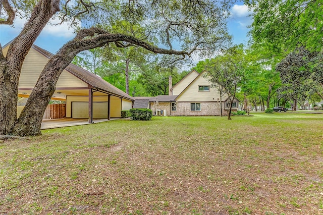 22814 Wren Ln, Tomball, TX 77377 - rear view of house featuring a yard, an attached garage, and driveway