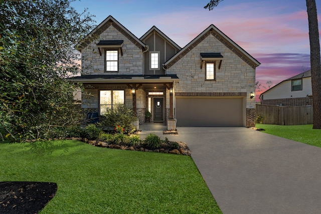 320 Cadela Dr, Montgomery, TX 77316 - view of front of property featuring a front yard, stone siding, concrete driveway, fence, and a garage