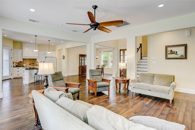 living room with ceiling fan, dark wood-type flooring, stairway, baseboards, and recessed lighting