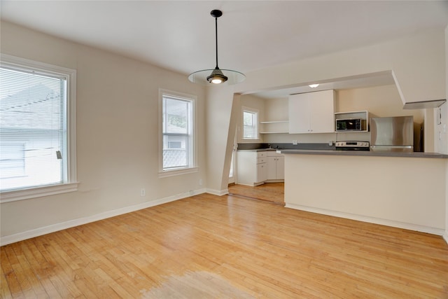 2348 Sheridan St, Houston, TX 77030 - kitchen with stainless steel appliances, open shelves, light wood finished floors, white cabinets, and plenty of natural light