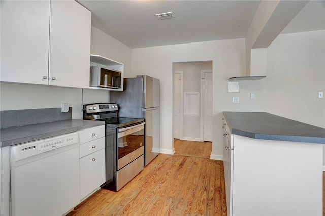 2348 Sheridan St, Houston, TX 77030 - kitchen with stainless steel appliances, white cabinets, light wood-style floors, and dark countertops