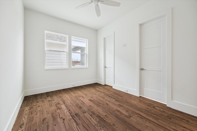 unfurnished bedroom with ceiling fan, dark wood-style floors, and baseboards