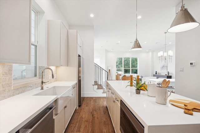 kitchen with white cabinetry, light countertops, appliances with stainless steel finishes, an island with sink, and dark wood finished floors