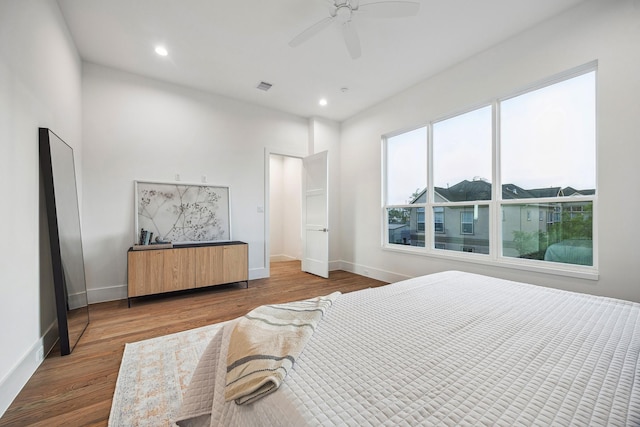 bedroom with wood finished floors, visible vents, recessed lighting, and baseboards