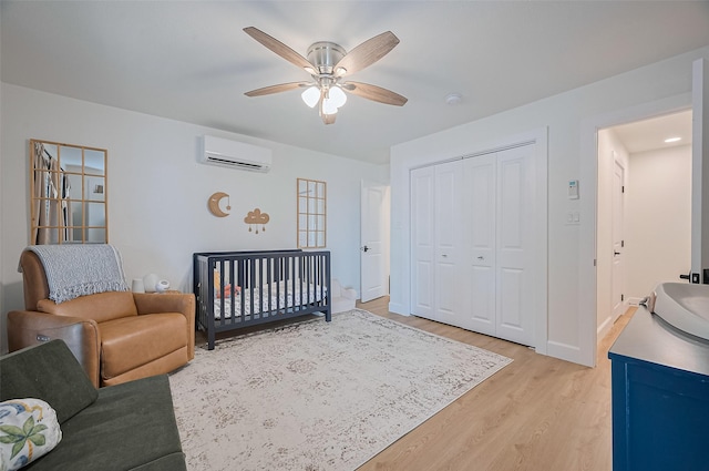 3734 Windswept Dr, Montgomery, TX 77356 - bedroom featuring a wall unit AC, light wood finished floors, a closet, a ceiling fan, and baseboards
