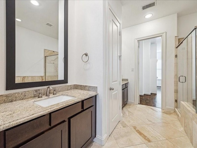 bathroom featuring visible vents, a shower stall, and vanity