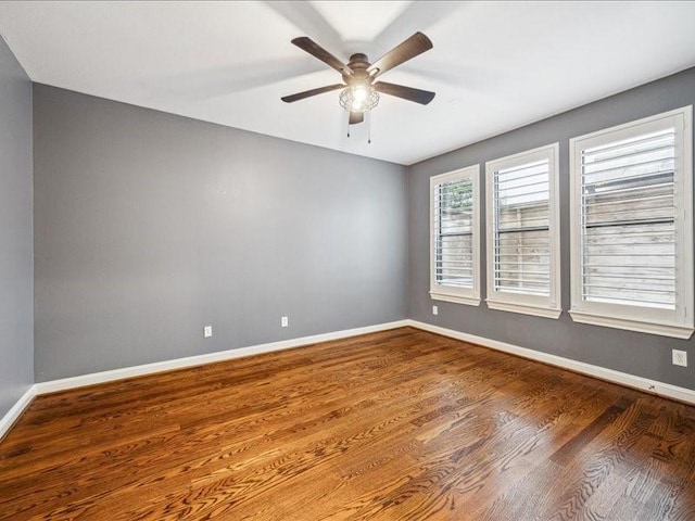 spare room featuring wood finished floors, ceiling fan, and baseboards