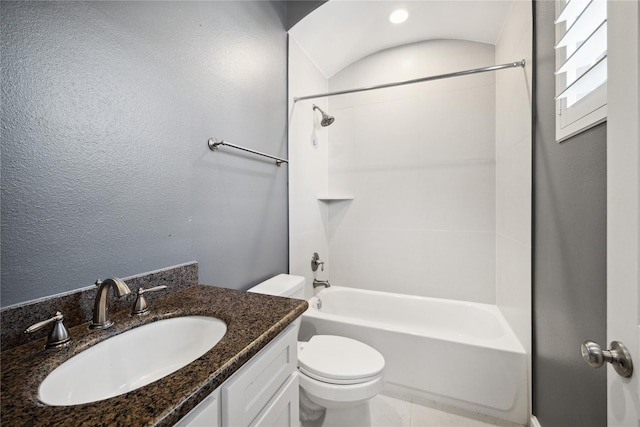 bathroom with toilet, shower / bathing tub combination, vanity, and a textured wall