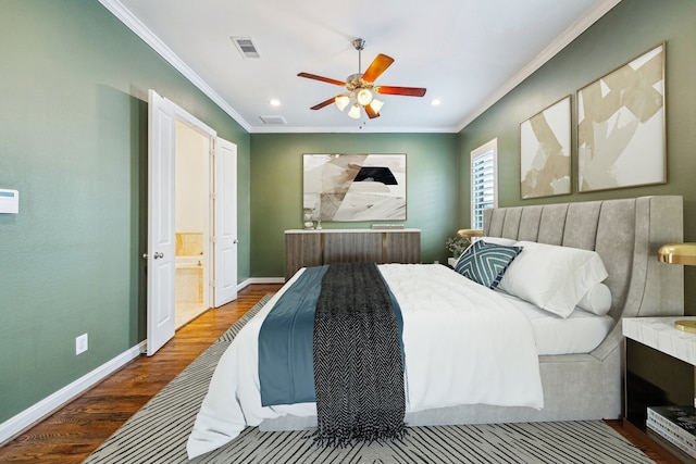 bedroom featuring baseboards, ornamental molding, ensuite bath, visible vents, and wood finished floors