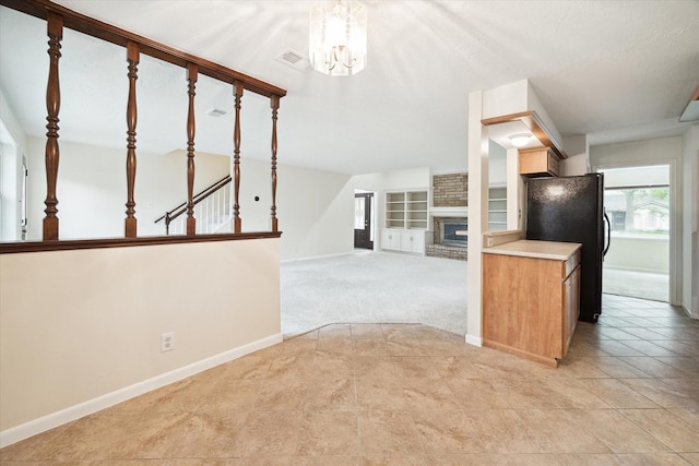 6106 Greenmont Dr, Houston, TX 77092 - kitchen featuring a brick fireplace, freestanding refrigerator, healthy amount of natural light, and a chandelier