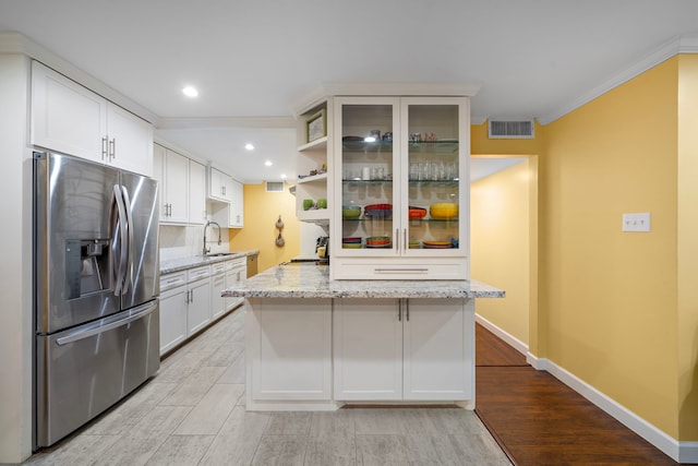 7575 Katy Fwy Unit 4, Houston, TX 77024 - kitchen featuring stainless steel refrigerator with ice dispenser, a sink, light wood-type flooring, crown molding, and light stone counters