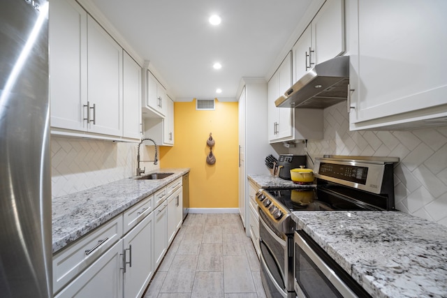 7575 Katy Fwy Unit 4, Houston, TX 77024 - kitchen featuring under cabinet range hood, appliances with stainless steel finishes, a sink, recessed lighting, and decorative backsplash