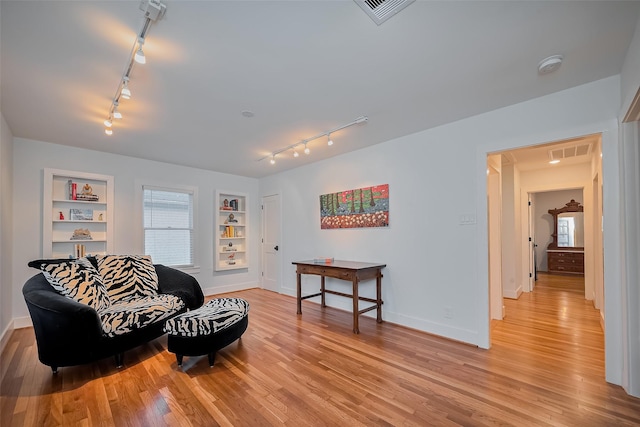2311 Branard St, Houston, TX 77098 - sitting room with light wood-style floors, rail lighting, built in shelves, and visible vents
