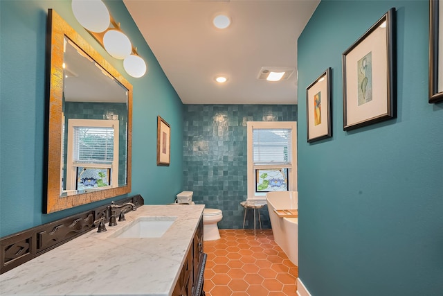 2311 Branard St, Houston, TX 77098 - bathroom with toilet, a healthy amount of sunlight, a freestanding tub, and tile walls