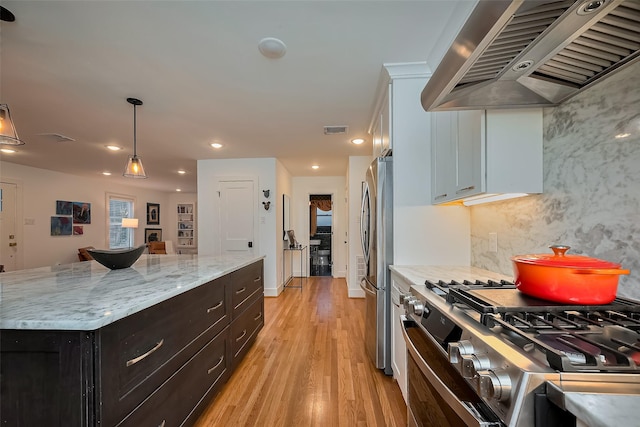 2311 Branard St, Houston, TX 77098 - kitchen with light wood-style floors, pendant lighting, stainless steel appliances, visible vents, and ventilation hood