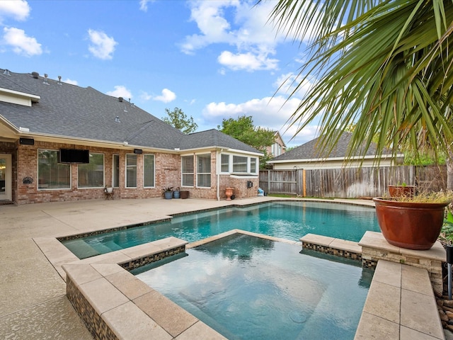 view of pool featuring a patio, a pool with connected hot tub, and a fenced backyard