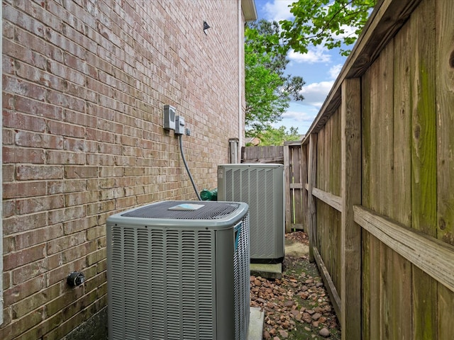 exterior view of cooling unit, brick siding, and fence