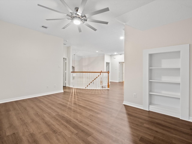 spare room featuring built in features, ceiling fan, baseboards, wood finished floors, and recessed lighting