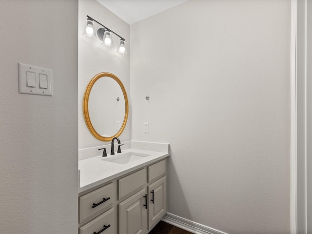 bathroom with vanity, baseboards, and wood finished floors