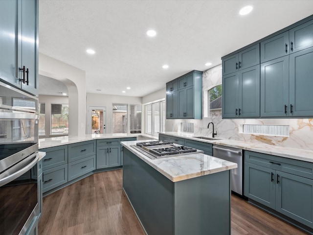 kitchen featuring stainless steel appliances, a sink, healthy amount of natural light, a peninsula, and recessed lighting