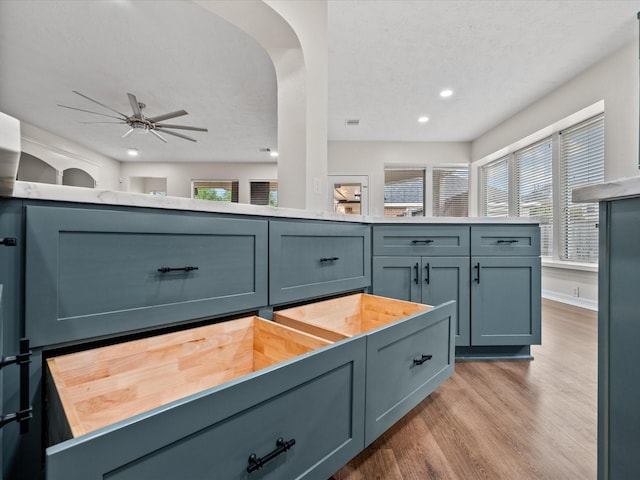 detailed view of wood finished floors, ceiling fan, recessed lighting, and arched walkways