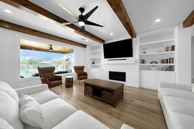 4730 Pitts Rd, Katy, TX 77493 - living area featuring a ceiling fan, beamed ceiling, a fireplace, light wood-style floors, and recessed lighting