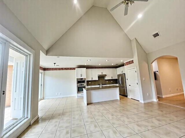 2914 Renoir, Sugar Land, TX 77479 - kitchen with stainless steel appliances, arched walkways, open floor plan, a ceiling fan, and light tile patterned floors