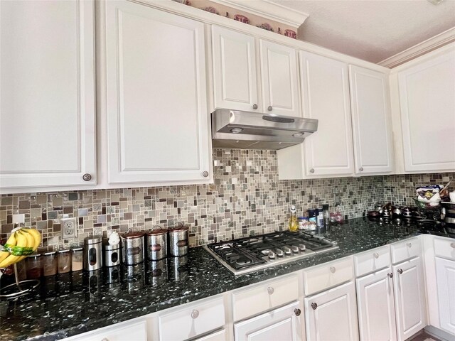 2914 Renoir, Sugar Land, TX 77479 - kitchen with under cabinet range hood, stainless steel gas stovetop, white cabinetry, tasteful backsplash, and dark stone countertops