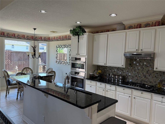 2914 Renoir, Sugar Land, TX 77479 - kitchen with appliances with stainless steel finishes, white cabinetry, tasteful backsplash, a textured ceiling, and under cabinet range hood