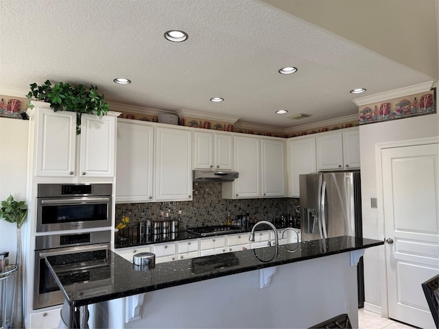 2914 Renoir, Sugar Land, TX 77479 - kitchen with appliances with stainless steel finishes, under cabinet range hood, white cabinetry, a kitchen breakfast bar, and ornamental molding
