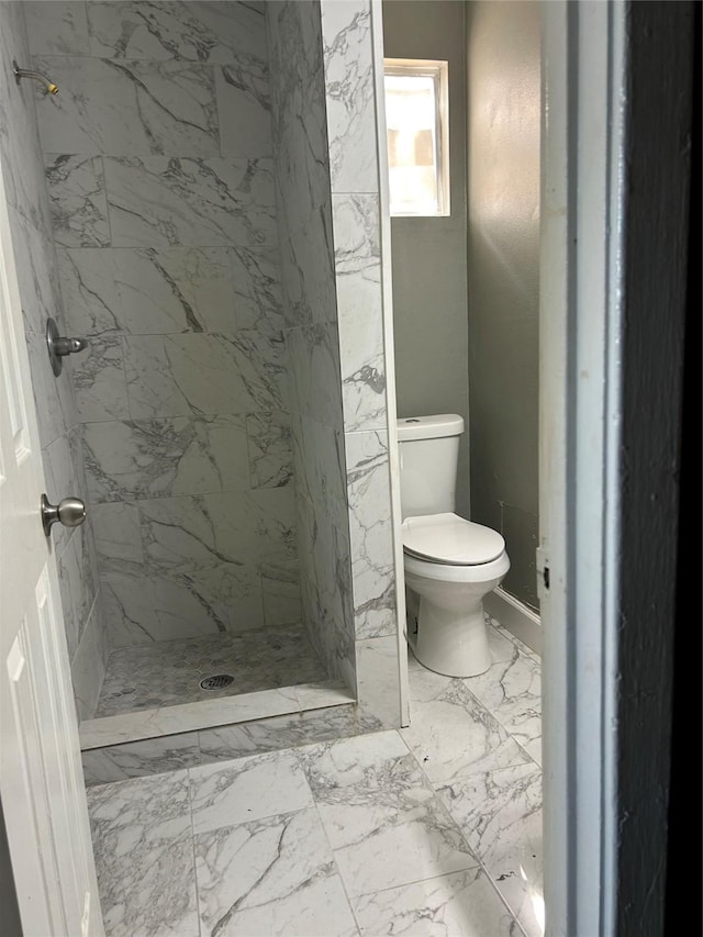bathroom featuring marble look tile flooring, a stall shower, and toilet