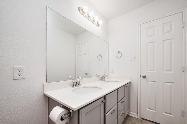 bathroom with double vanity, tile patterned flooring, and a sink