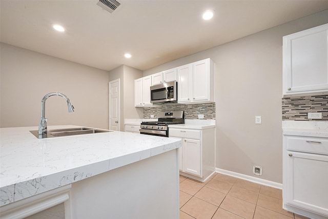 kitchen with a sink, white cabinets, visible vents, and stainless steel appliances