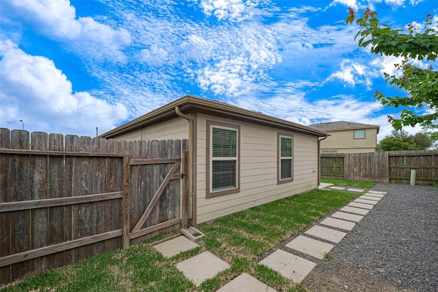 view of outbuilding featuring a fenced backyard and a gate