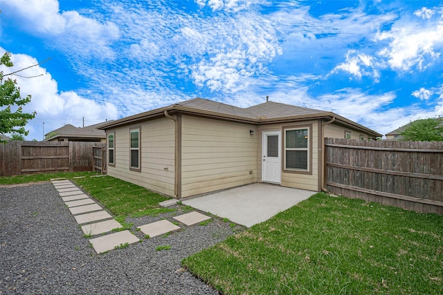 back of house featuring a fenced backyard, a yard, and a patio area