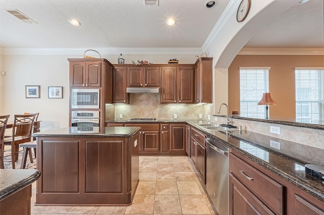 14515 Basalt Ln, Houston, TX 77077 - kitchen with a sink, appliances with stainless steel finishes, visible vents, under cabinet range hood, and arched walkways
