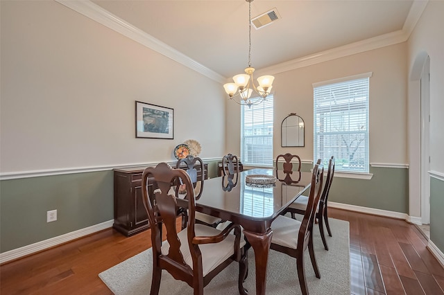 14515 Basalt Ln, Houston, TX 77077 - dining area featuring wood finished floors, a chandelier, baseboards, visible vents, and crown molding