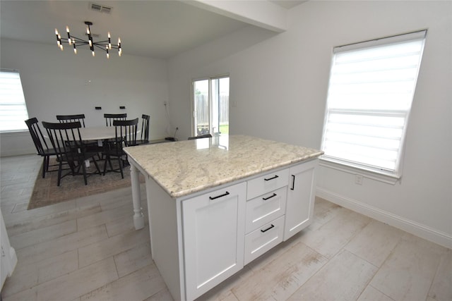 42 County Road 5102l, Cleveland, TX 77327 - kitchen with a chandelier, a kitchen island, white cabinets, and plenty of natural light