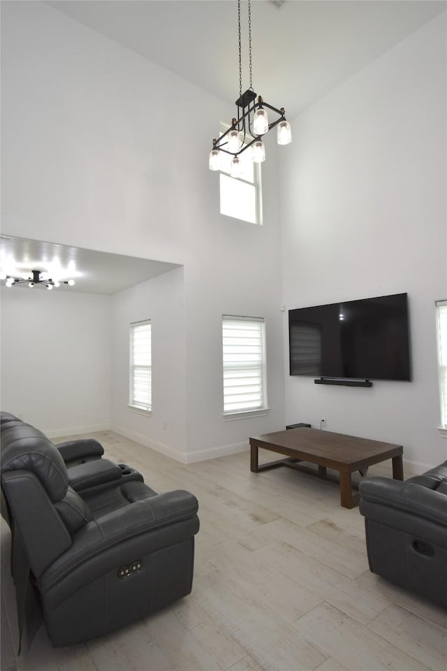 42 County Road 5102l, Cleveland, TX 77327 - living room featuring a towering ceiling, light wood-style flooring, baseboards, and a chandelier