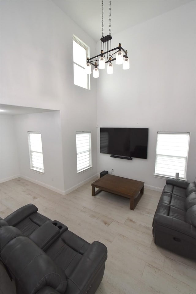 42 County Road 5102l, Cleveland, TX 77327 - living area featuring a towering ceiling, baseboards, a chandelier, and wood finished floors