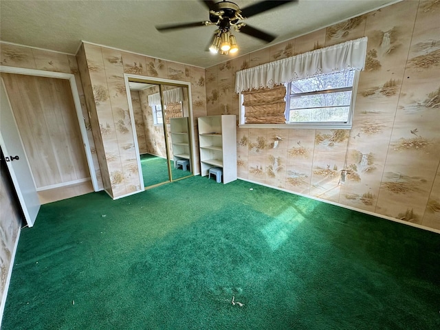 unfurnished bedroom with ceiling fan, carpet floors, wallpapered walls, and a closet