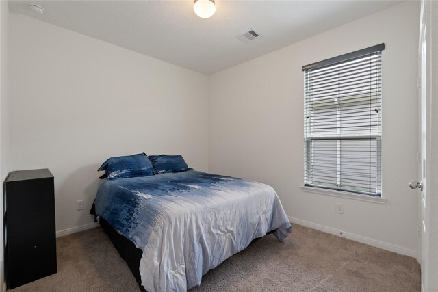 carpeted bedroom with visible vents and baseboards