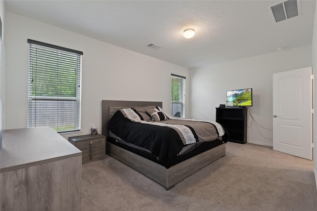 bedroom with visible vents and light colored carpet