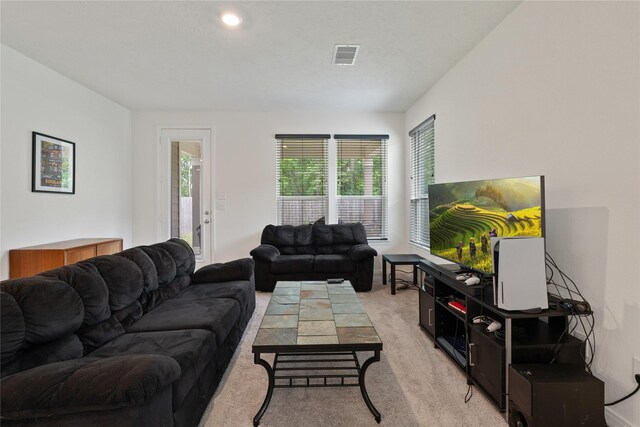 living area featuring visible vents and light carpet
