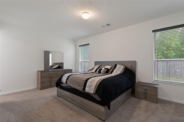 bedroom featuring carpet flooring, multiple windows, and visible vents