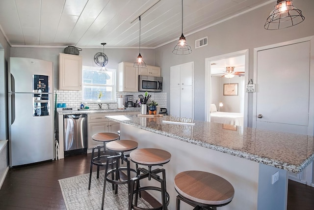 16519 Mansvelt Rd, Jamaica Beach, TX 77554 - kitchen featuring decorative backsplash, appliances with stainless steel finishes, a breakfast bar, and visible vents