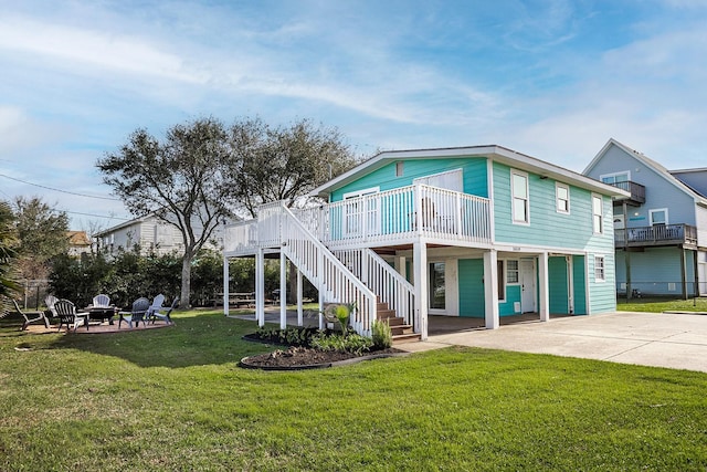 16519 Mansvelt Rd, Jamaica Beach, TX 77554 - back of property featuring a patio, an outdoor fire pit, concrete driveway, stairway, and a yard